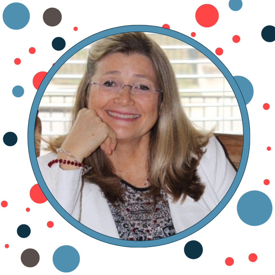 Woman smiling, wearing glasses and a white blazer, in a round blue frame with colorful dots.