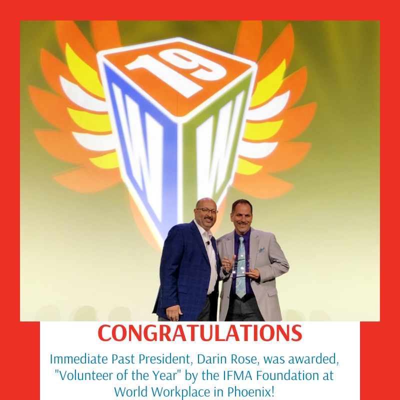 Two men on stage holding an award. 