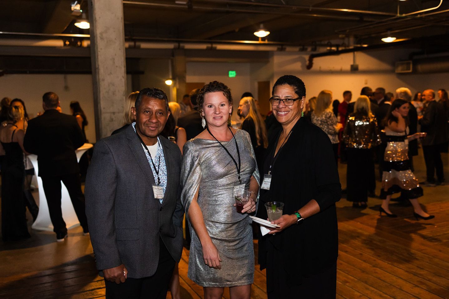 Three people at an event, smiling.