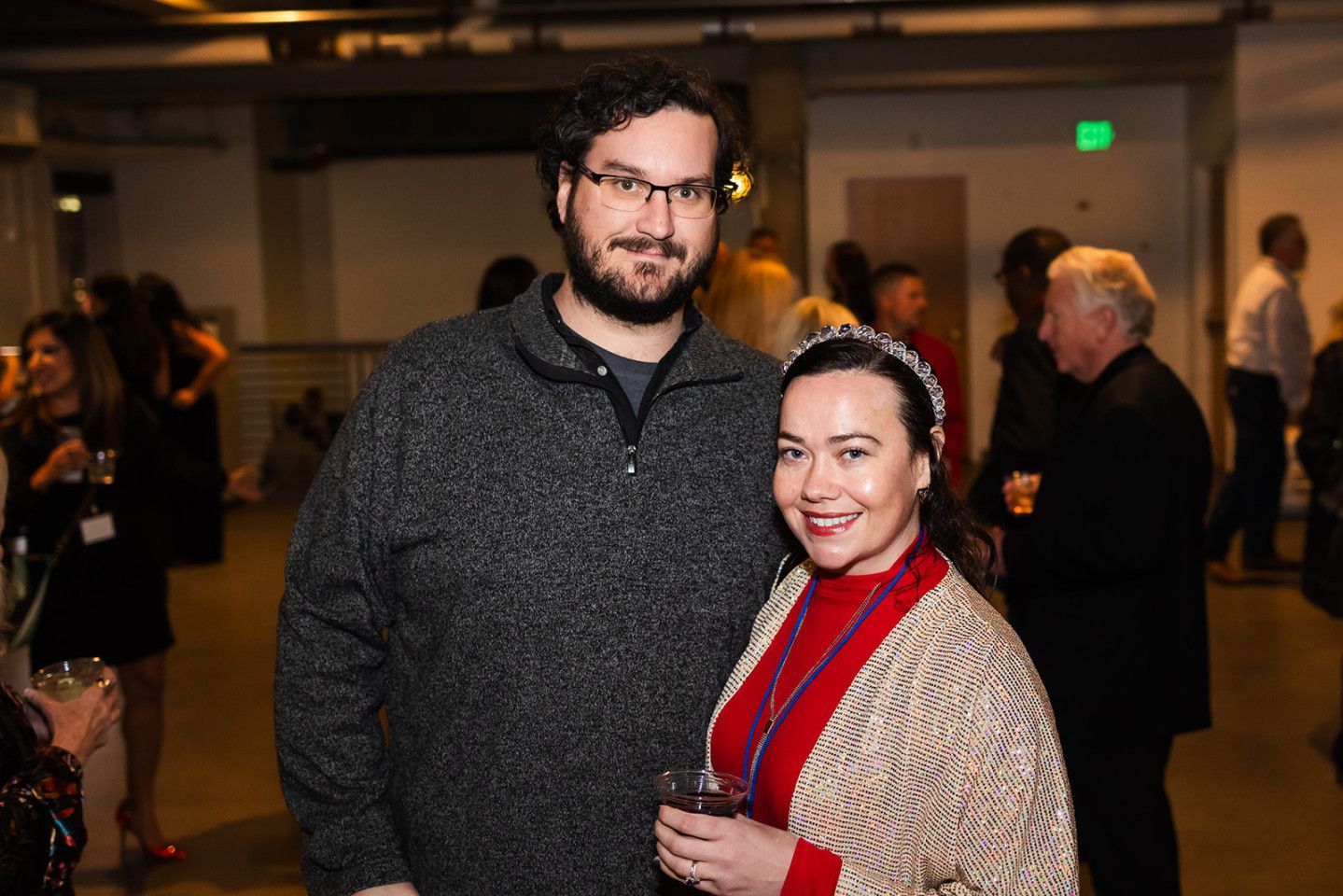 Man and woman smiling, indoors.