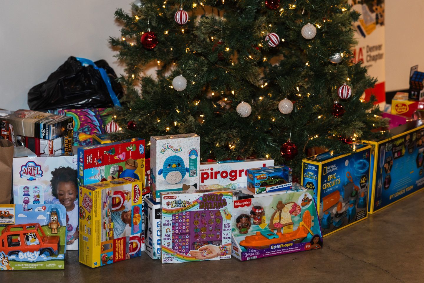 Christmas tree surrounded by wrapped presents, including toys and games.