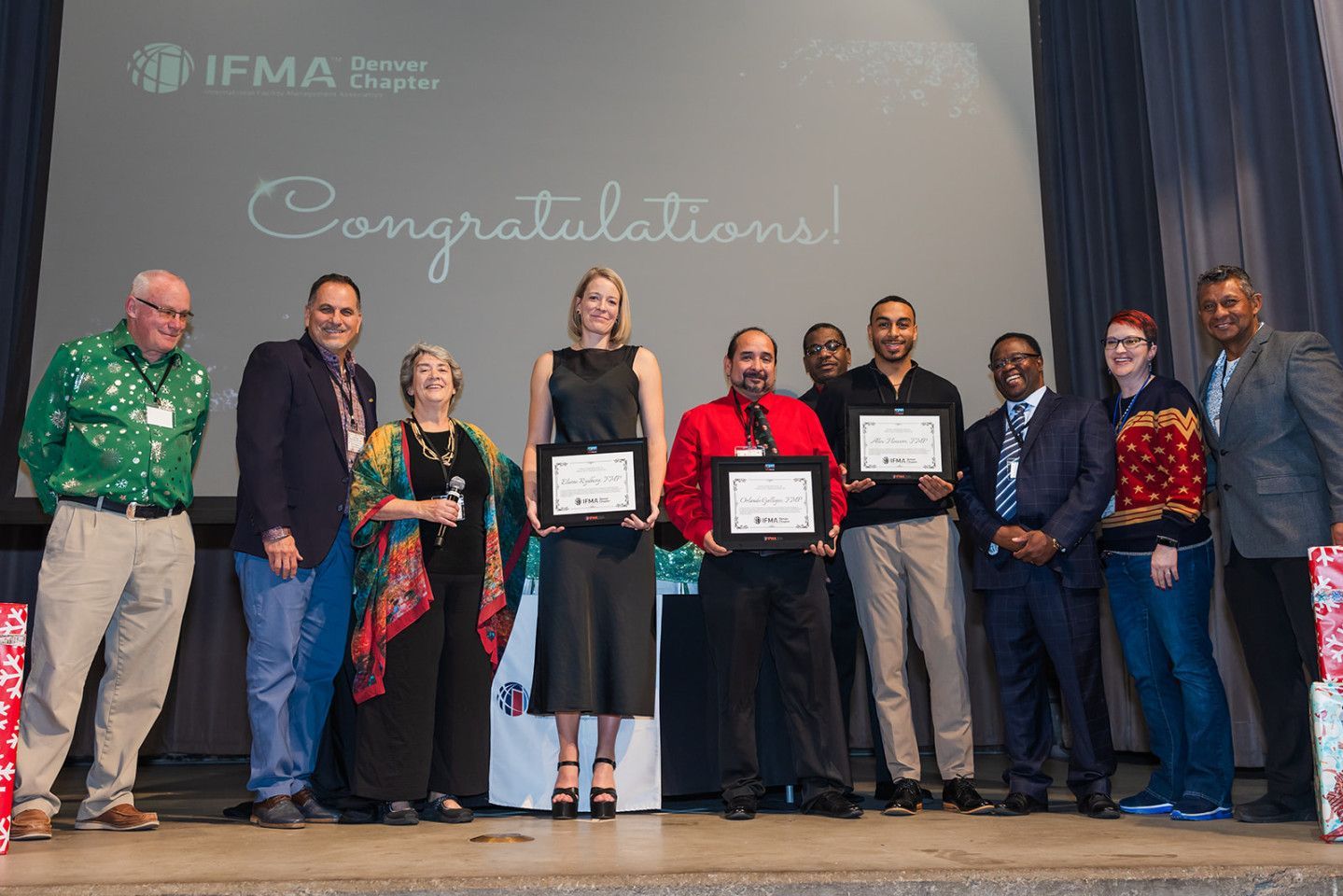 Group of people on stage holding certificates, with