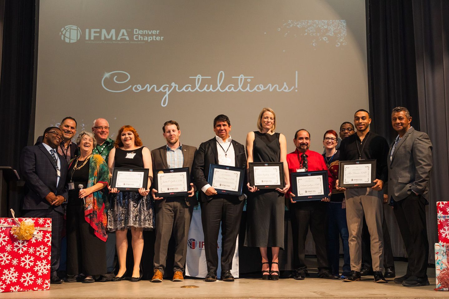 Group of people on stage holding certificates,