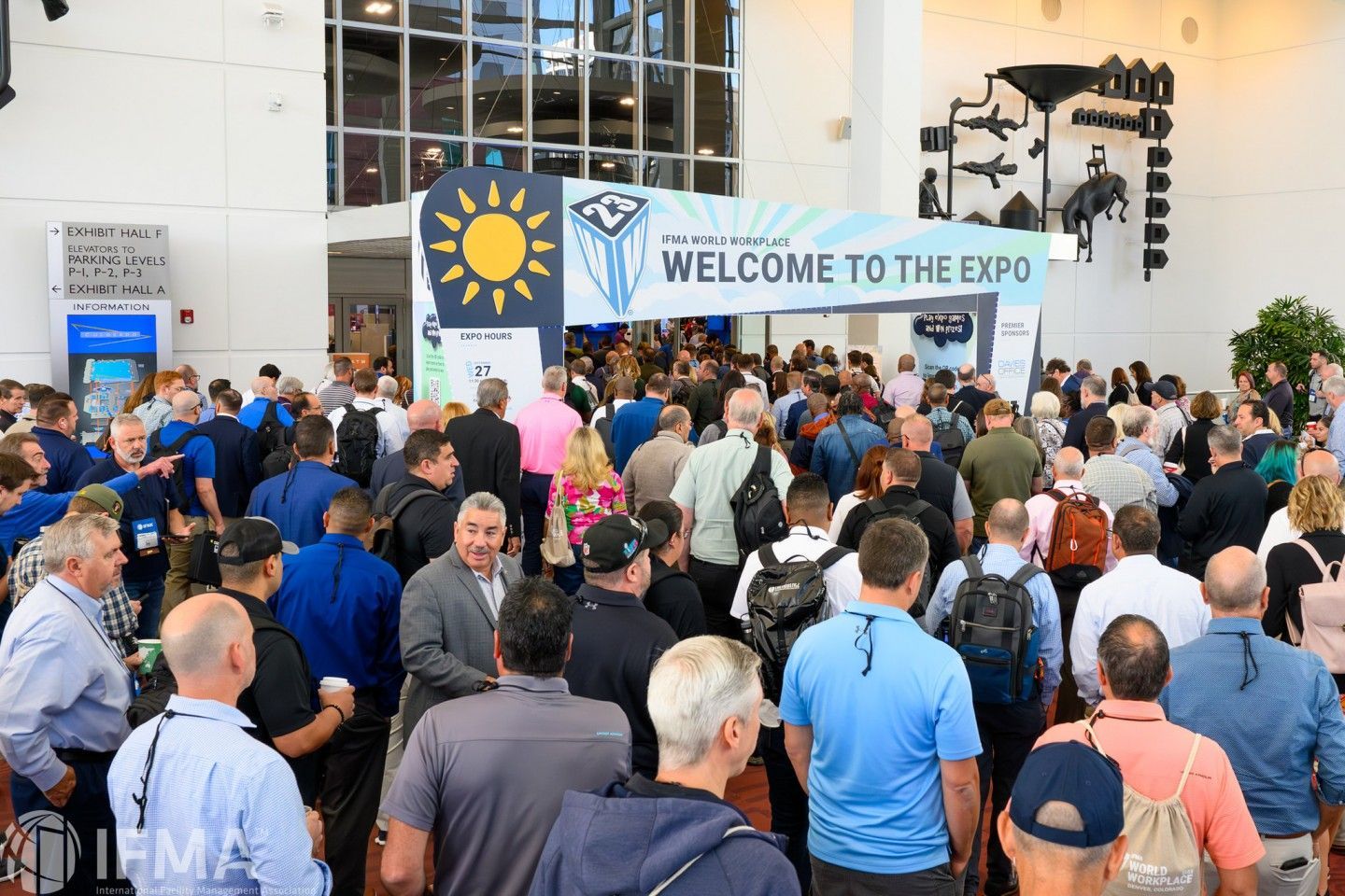 Crowd entering expo; banner reads
