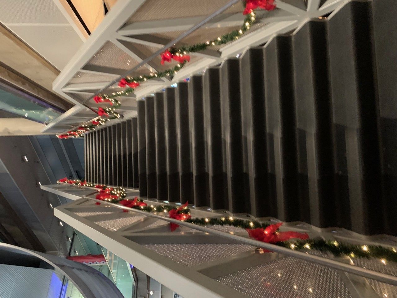 Festive garland with red bows and lights decorates a staircase.