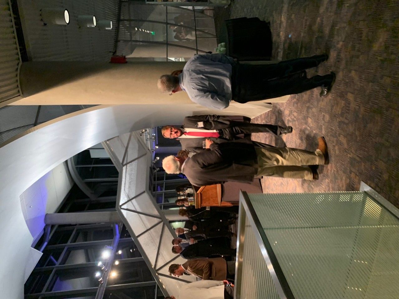 People at event in modern building with curved architecture and geometric structures.