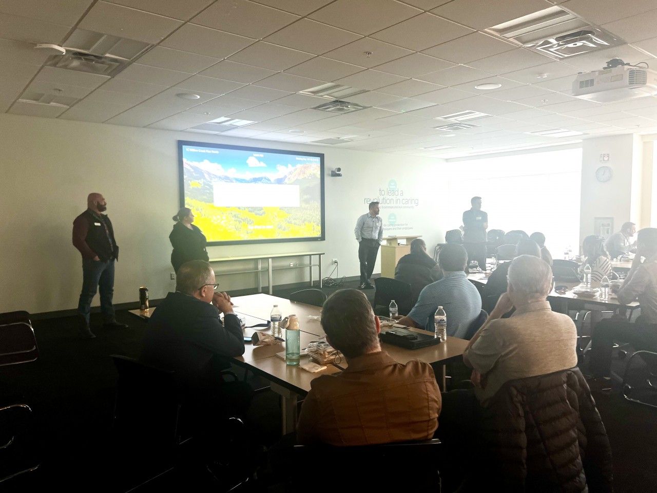 People in a conference room, listening to a presentation.