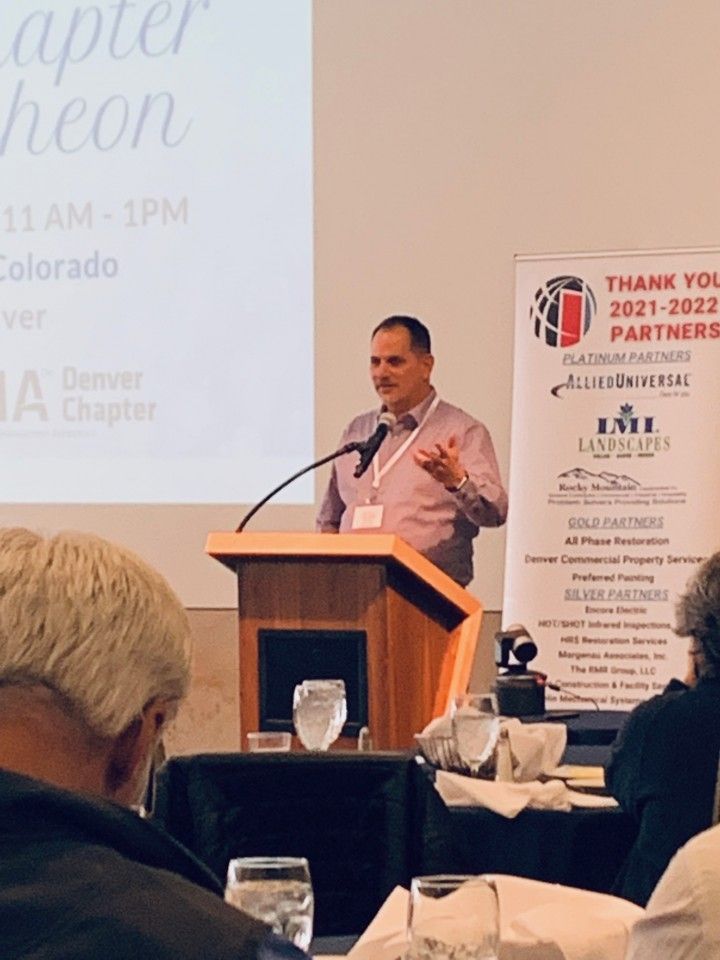 Man speaking at a podium during a conference. Banner with 