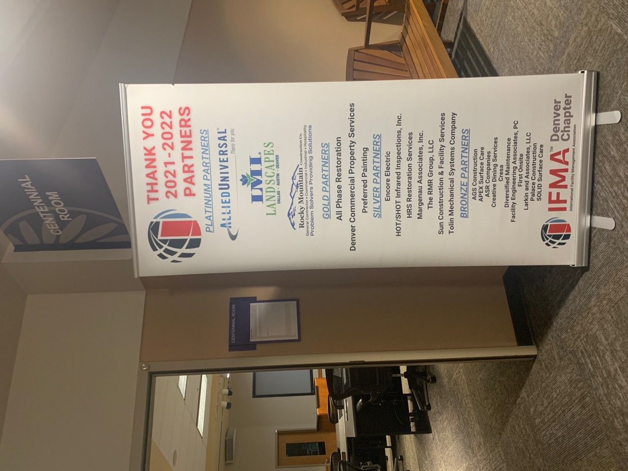 A banner thanking partners, 2021-2022, from the IFMA chapter. The banner is standing in a hallway.