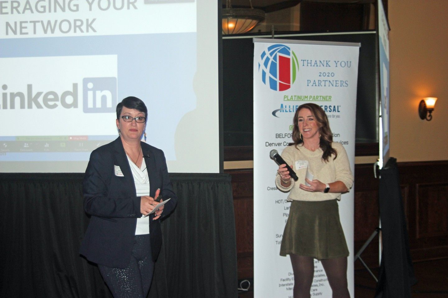 Two women at a presentation, one holding a microphone.