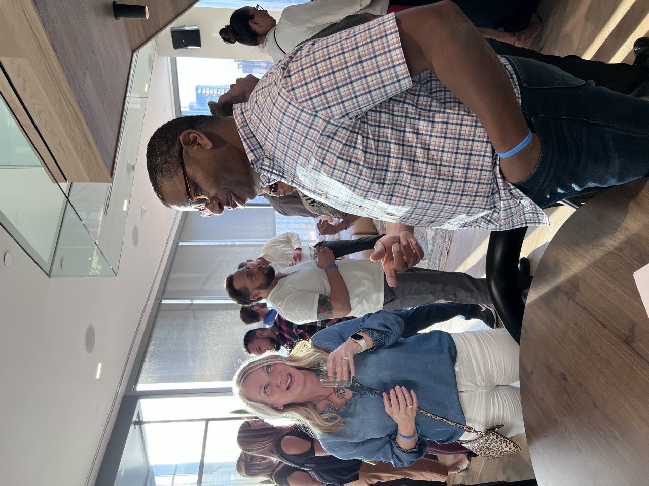 People in a group, some smiling, in a bright modern room.