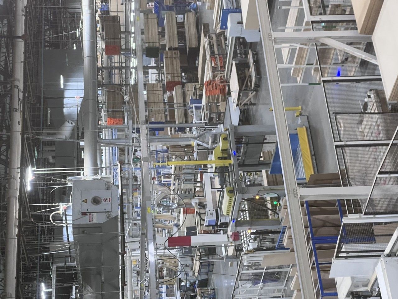 Factory interior with machinery, shelves, and various materials.