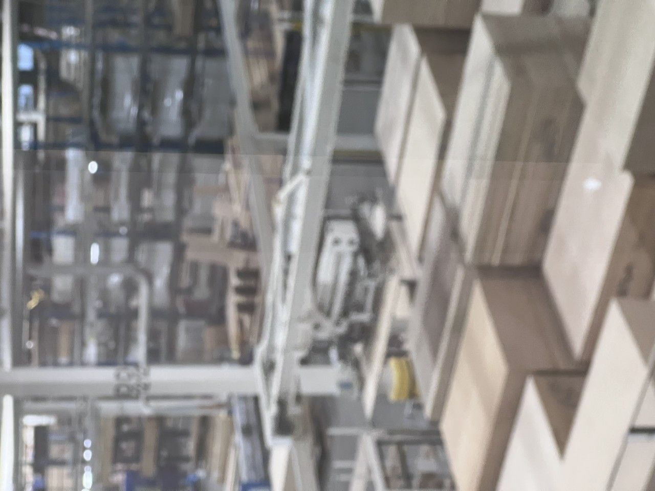 Warehouse interior with stacked wooden boxes and machinery.