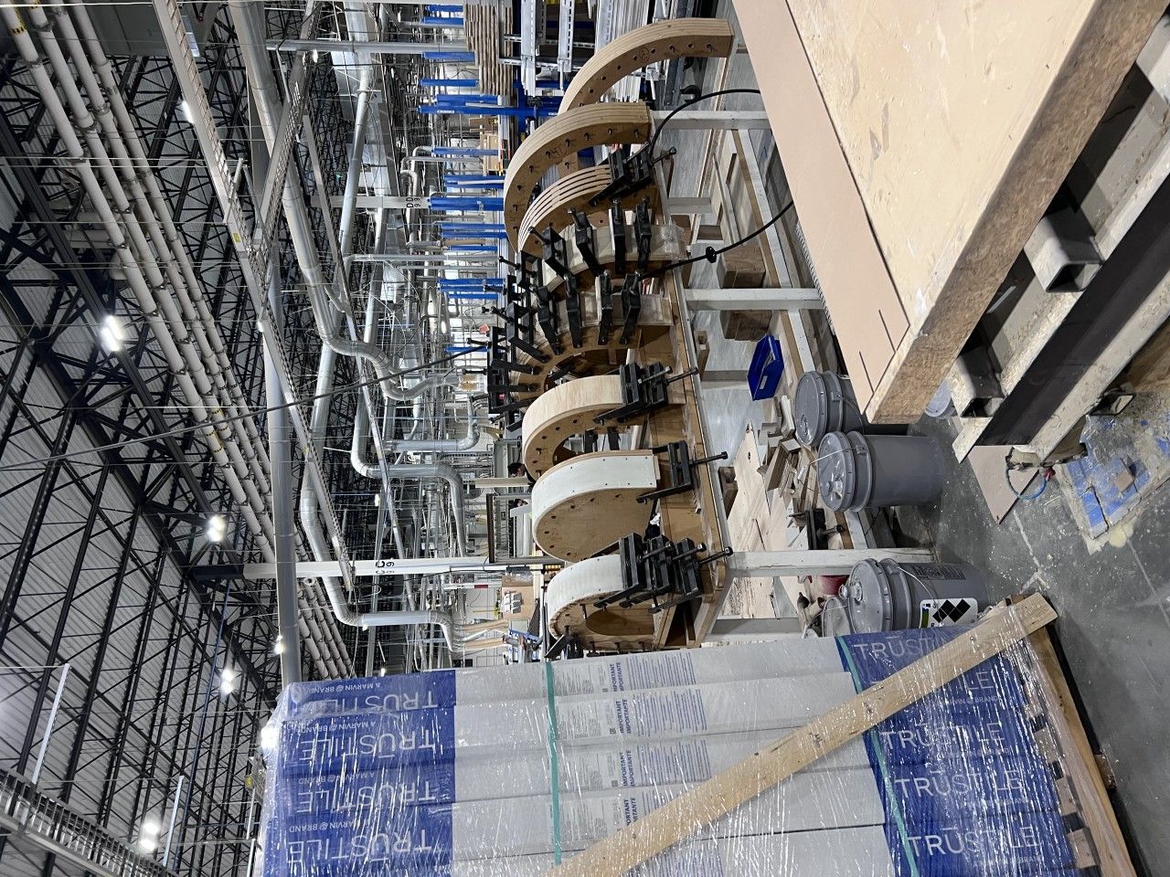Industrial machinery inside a warehouse; various metal pipes and conveyor belts.