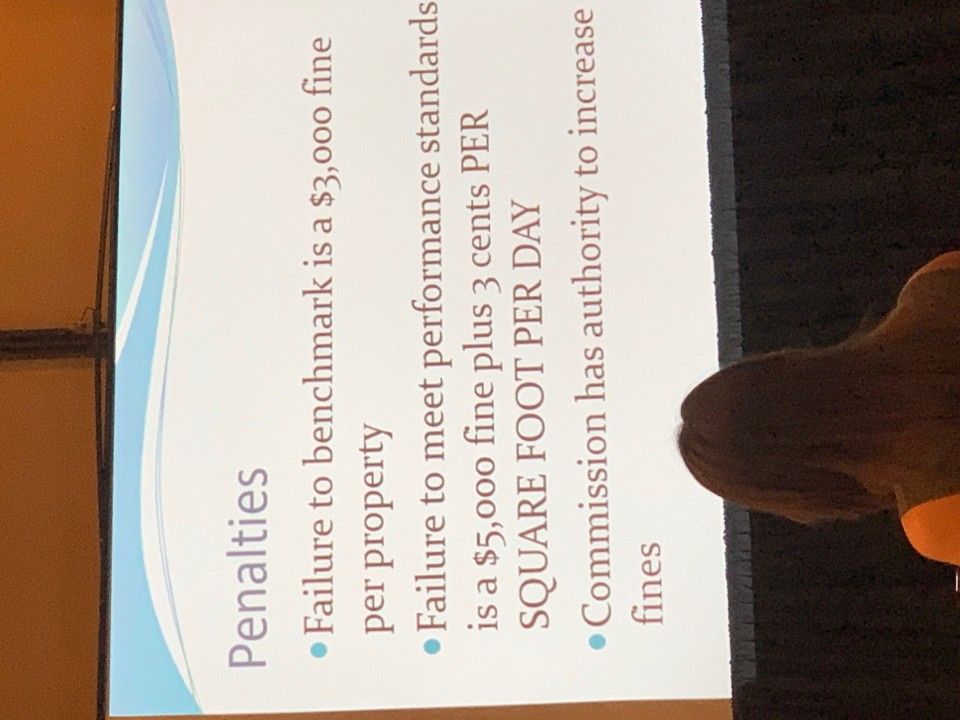 Slide detailing penalties for failing benchmarks: $3,000 fine, $5,000 fine + 3 cents/sq ft/day