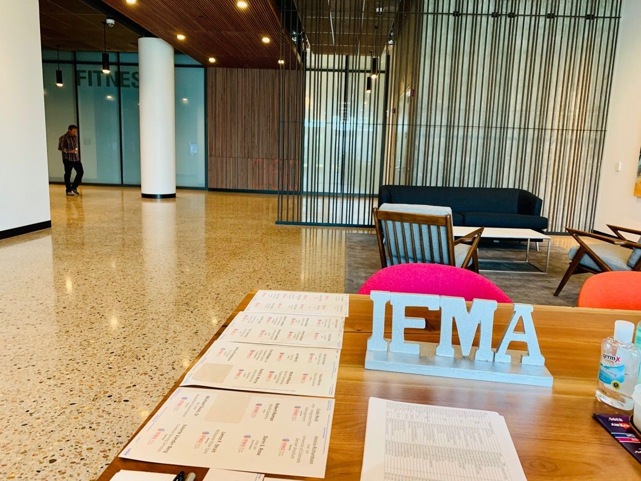 Lobby area with a front desk, seating, and a fitness room visible.