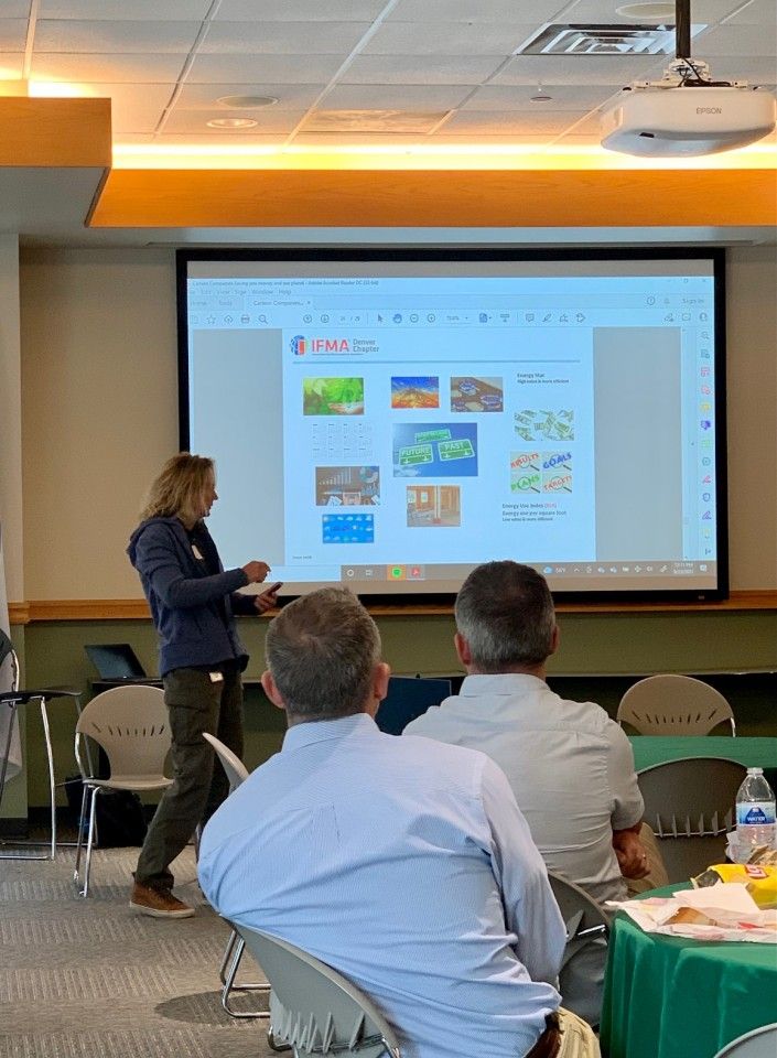 A person presenting a slideshow to an audience in a meeting room.