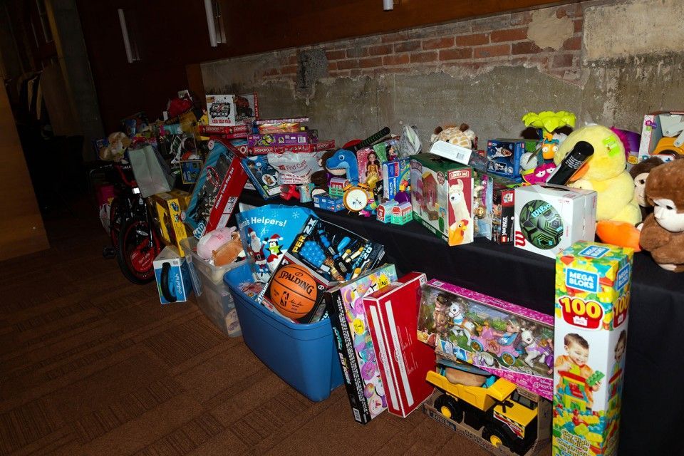 Toys displayed on a table. Various colors, including red, yellow, and blue. Brick wall background.