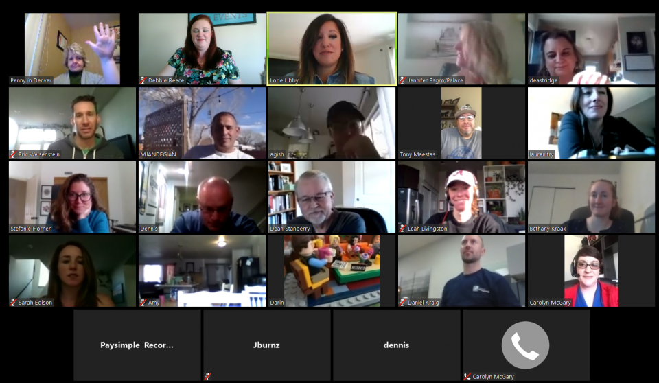 A virtual meeting with 25 people visible, smiling and waving. Mostly indoors with diverse backgrounds.