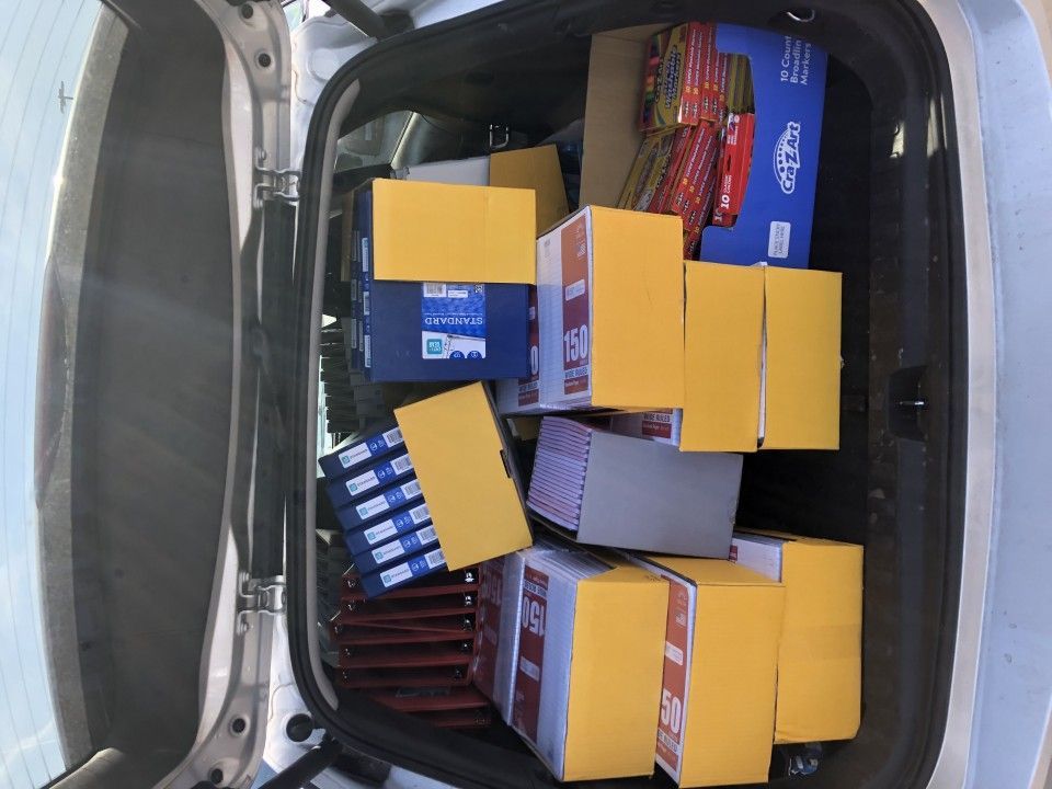 Open car trunk filled with boxes and packages, some with yellow labels.