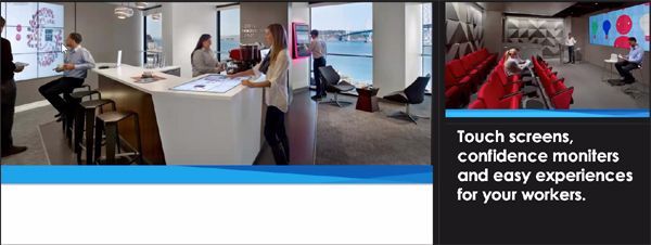 People working in a modern office space, featuring touch screens and monitors for workers.