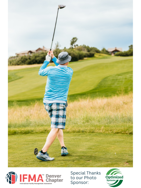 Person swings a golf club on a green course, wearing blue shirt, plaid shorts, and a hat.