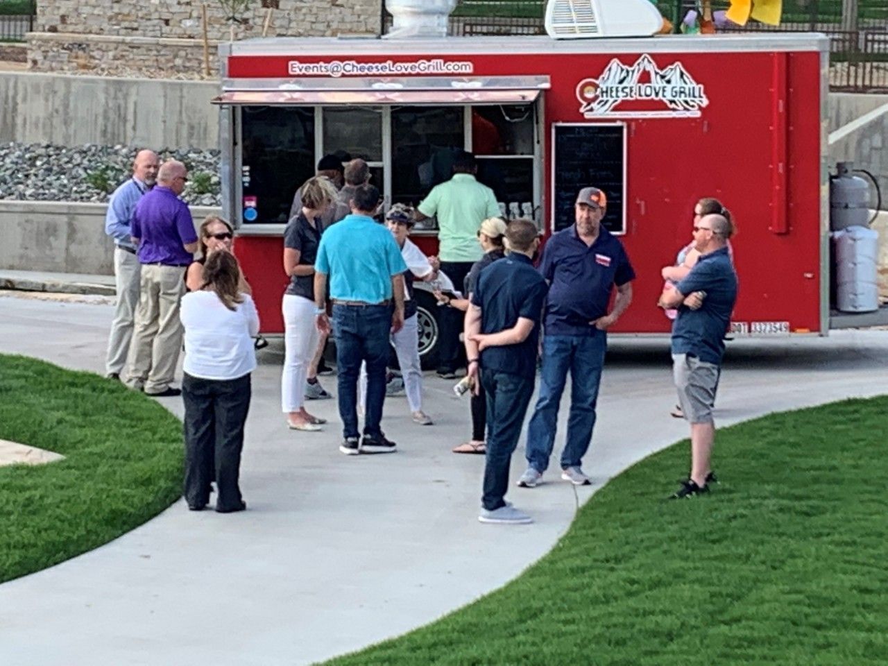 People line up at a red food truck with
