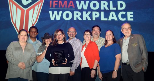 Group of people holding an award in front of an 