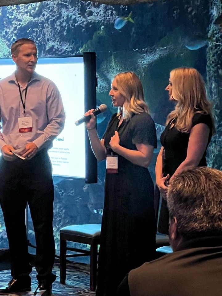 Three people at a conference.