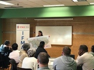 Woman presenting a map in front of a group. 