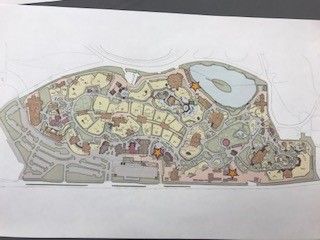 Top-down architectural map, beige and brown, of a large complex with buildings, roads, water feature.