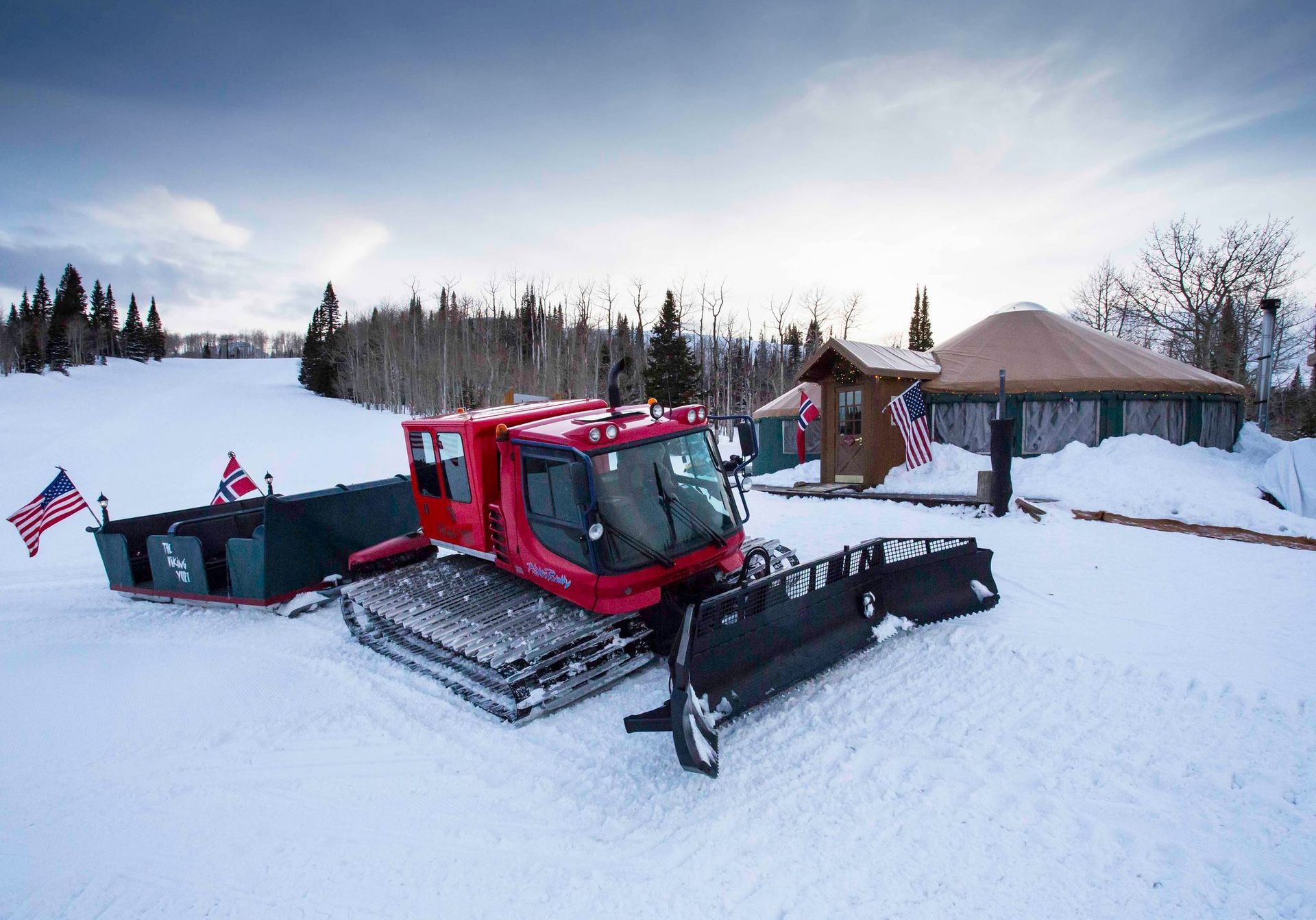 snow cat and sleigh in front of yurt