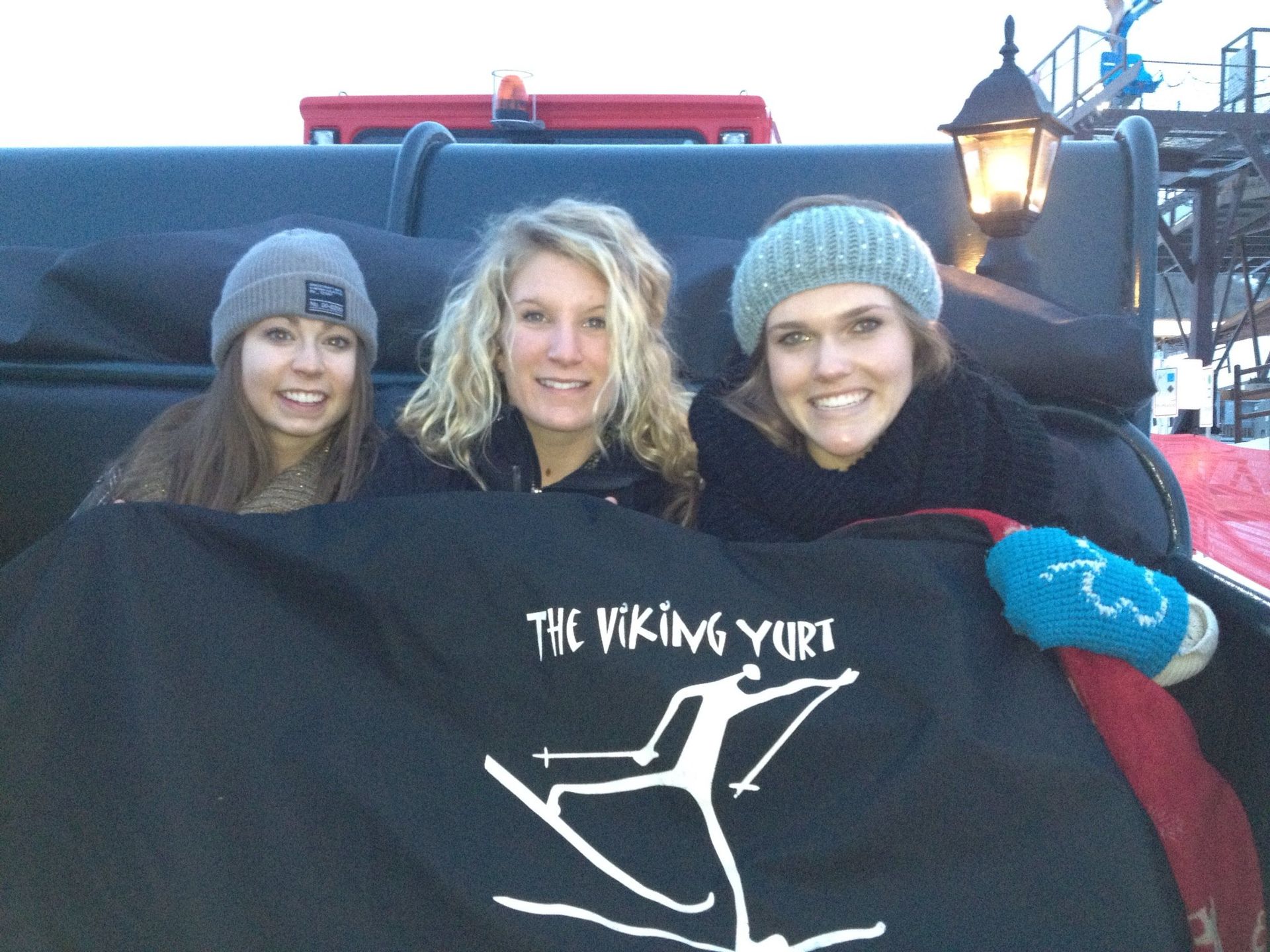 women on sleigh under a blanket