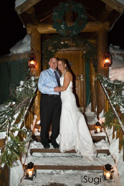 couple on steps of yurt in wedding attire