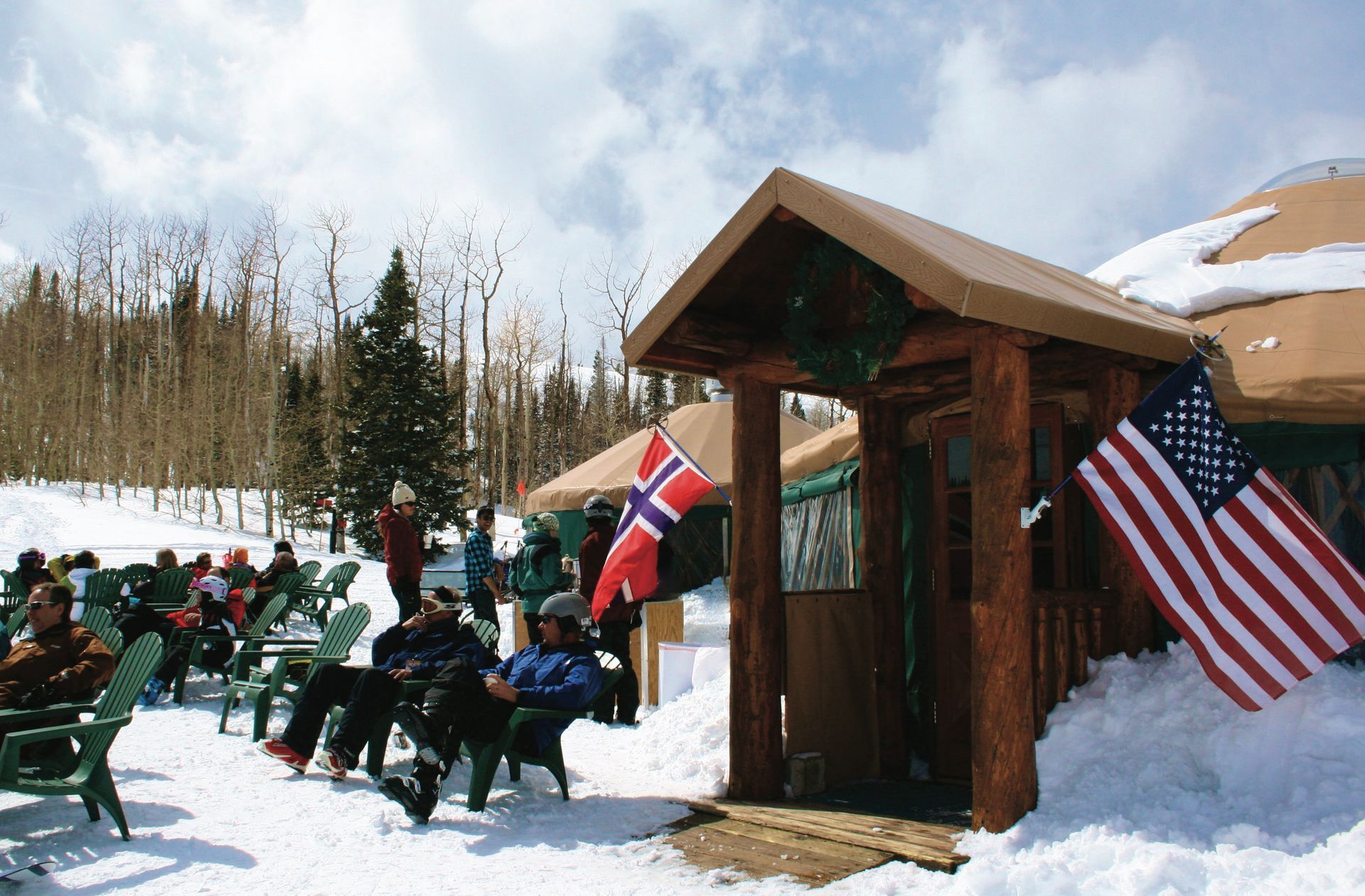 skiiers sitting outside the yurt during the day