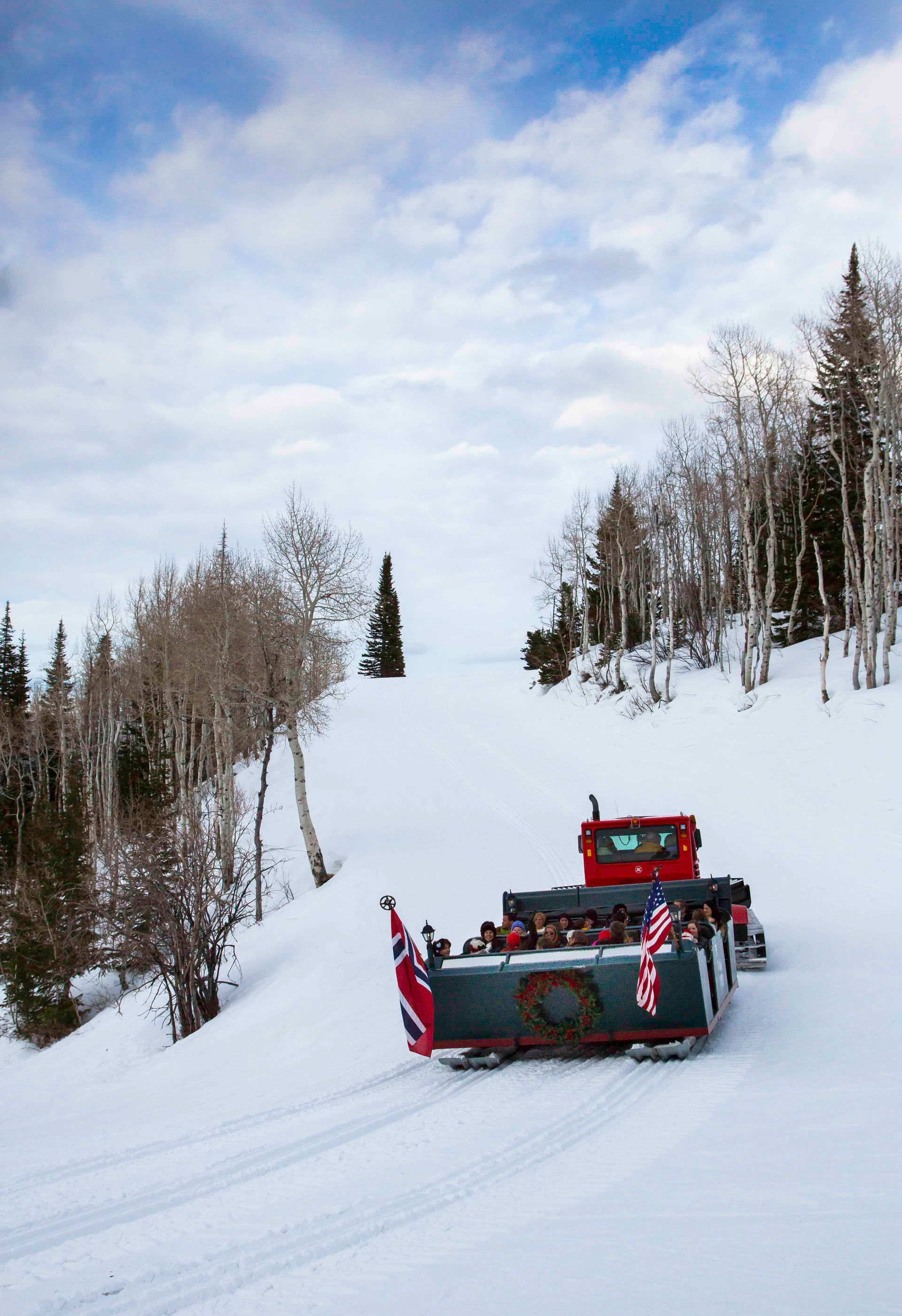 snow cat pulling people up a steep hill