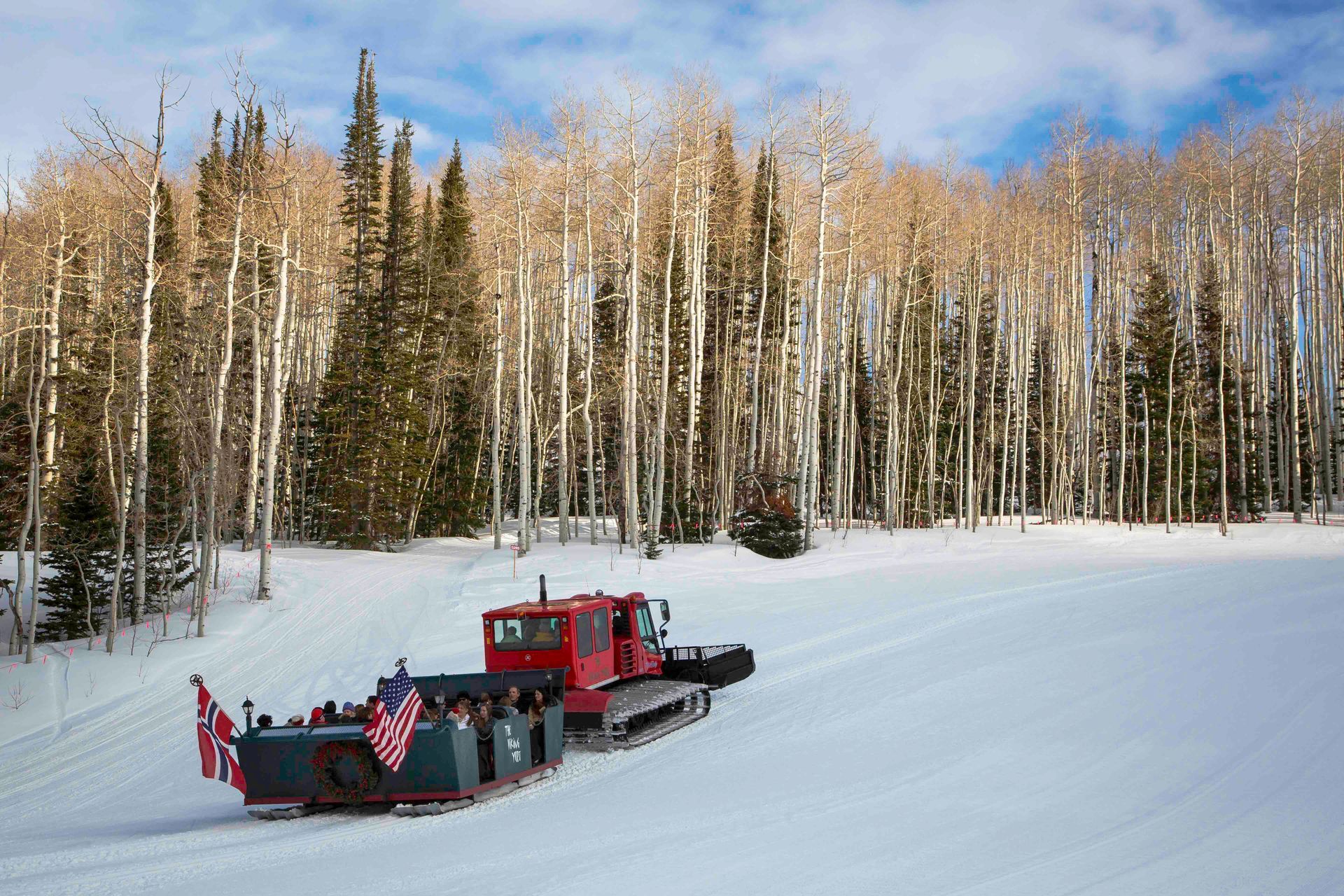 snowcat pulling sleigh full of people