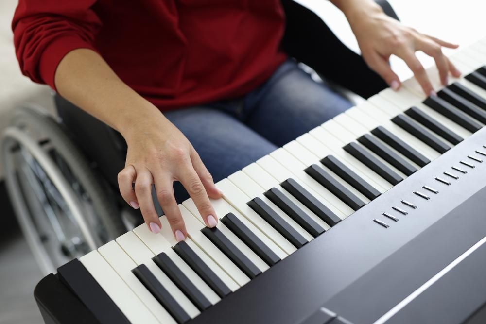 A Person in A Wheelchair Is Playing a Piano Keyboard — David Simpson Pty Ltd in Redlynch, QLD
