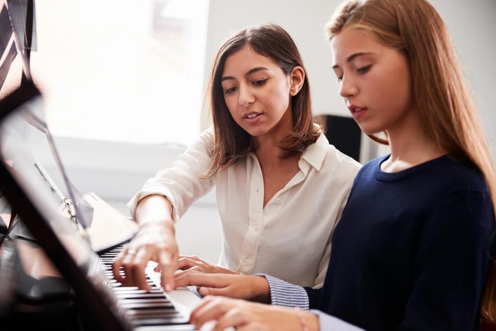 A Woman Is Teaching a Young Girl how To Play the Piano — David Simpson Pty Ltd in Atherton, QLD