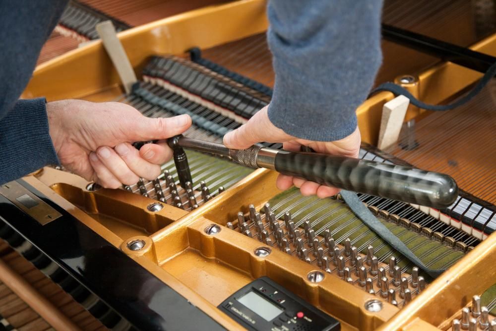 A Person Is Working on A Piano with A Screwdriver — David Simpson Pty Ltd in Redlynch, QLD