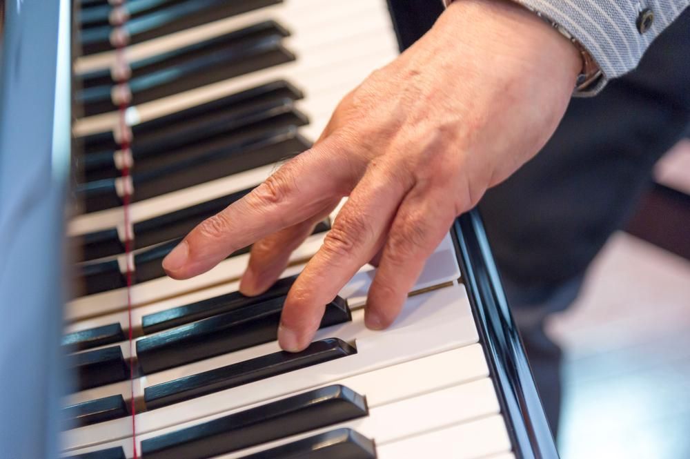 A Close up Of a Person's Hand Playing a Piano — David Simpson Pty Ltd in Mareeba, QLD