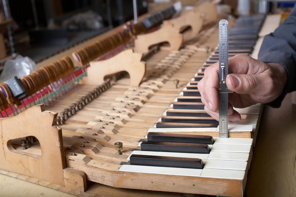 A Person Is Measuring a Piano Keyboard with A Ruler — David Simpson Pty Ltd in Innisfail, QLD