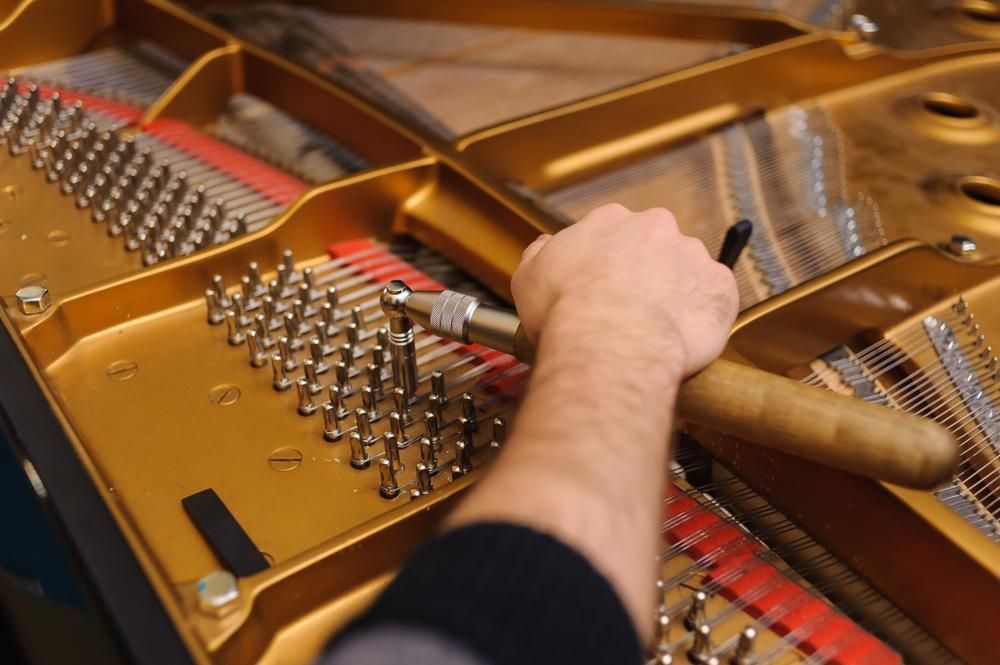 A Person Is Working on A Piano with A Screwdriver — David Simpson Pty Ltd in Redlynch, QLD