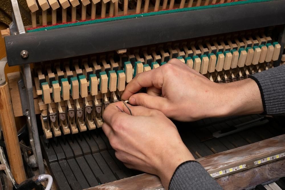 A Man Is Working on A Piano with His Hands — David Simpson Pty Ltd in Redlynch, QLD