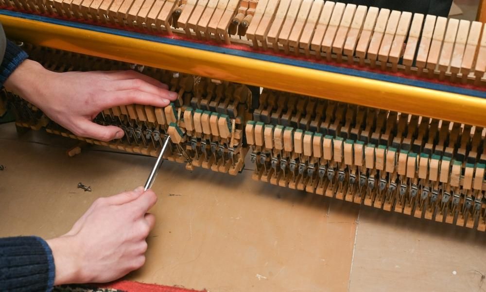 A Person Is Working on A Piano with A Screwdriver — David Simpson Pty Ltd in Atherton, QLD
