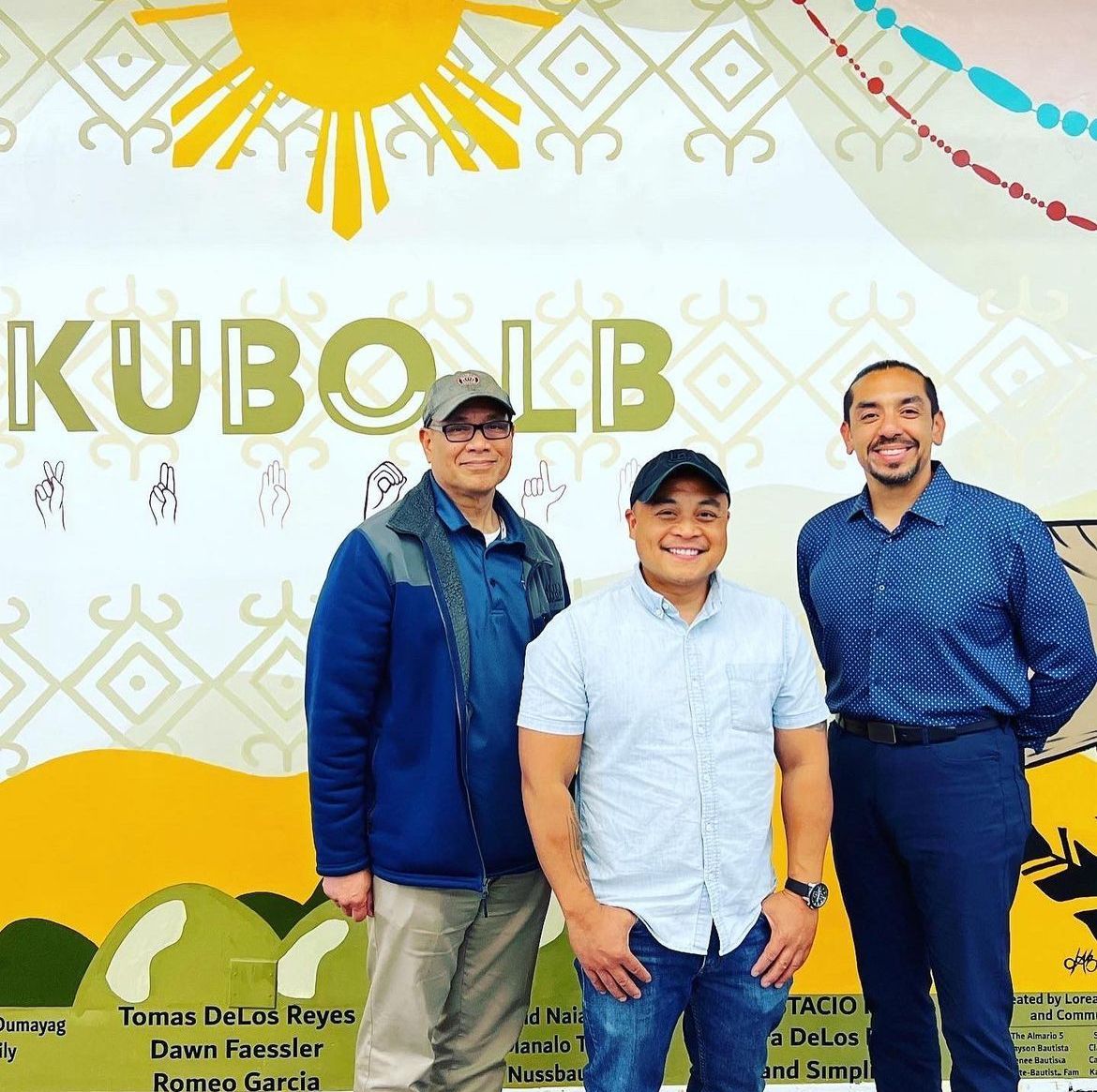 Three men standing in front of a mural, the logo "KUBO LB" is visible.