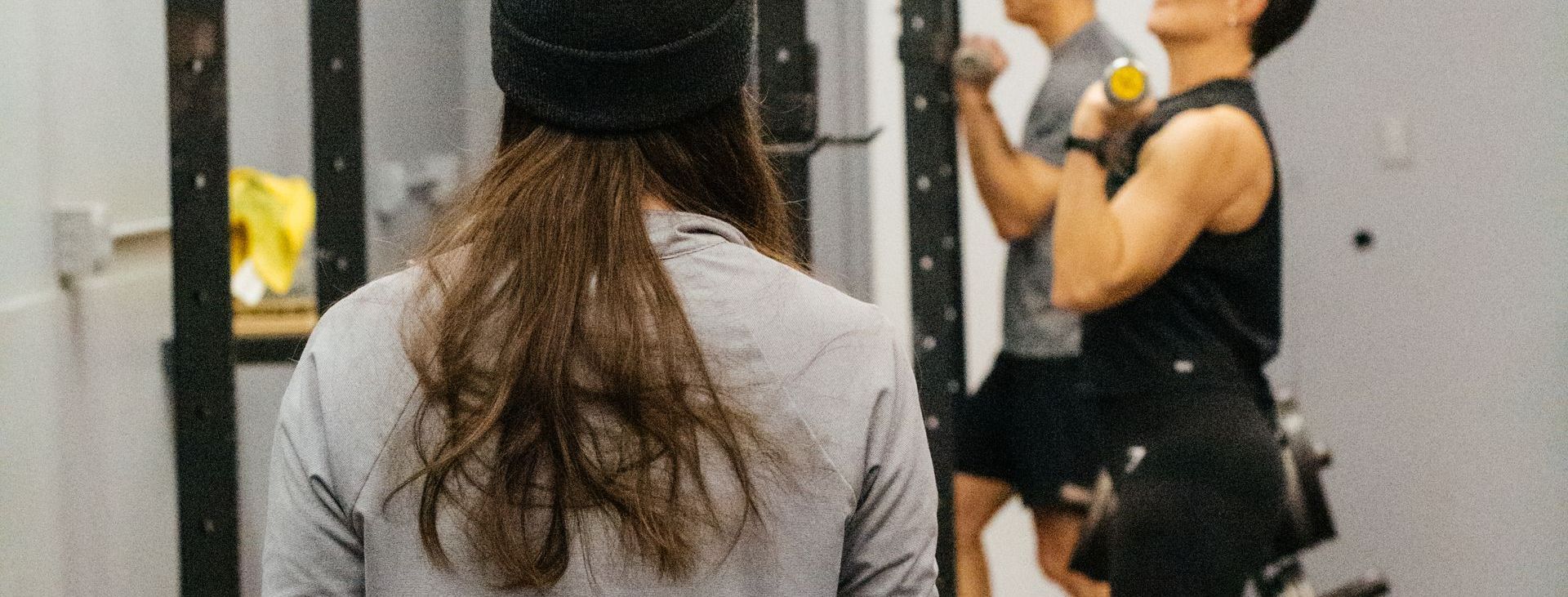 A woman is standing in front of a group of people in a gym.