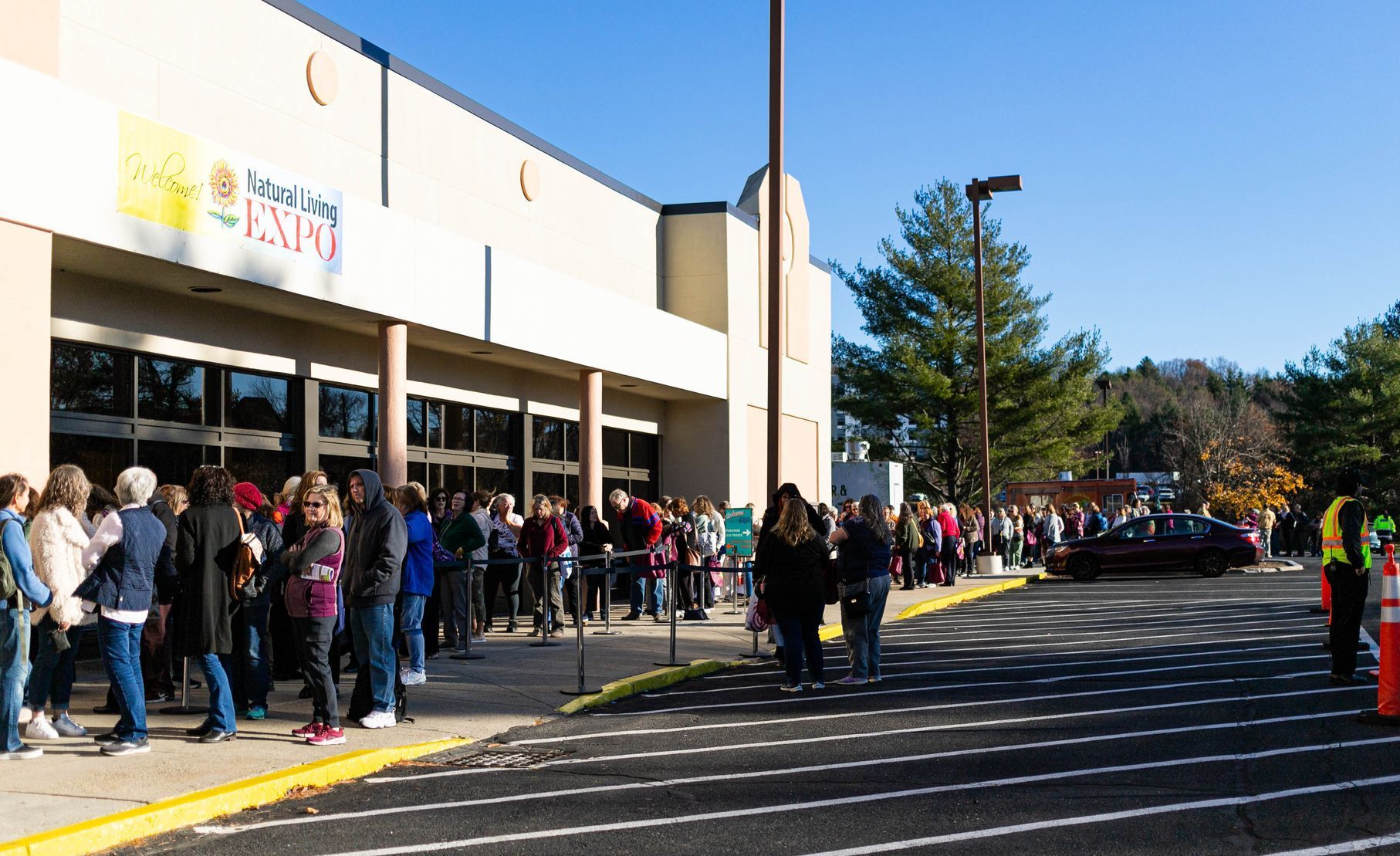 A woman sits on the floor while another woman holds a green bowl
