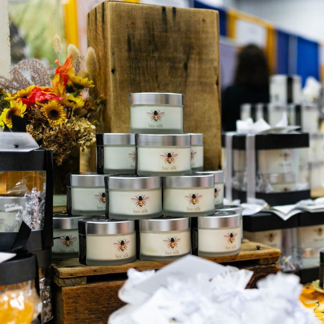 A woman stands behind a table selling vegan non-gmo products