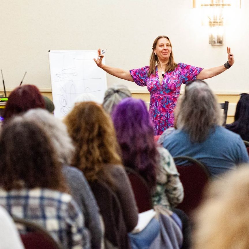 A woman in a red and white dress stands in front of a group of people